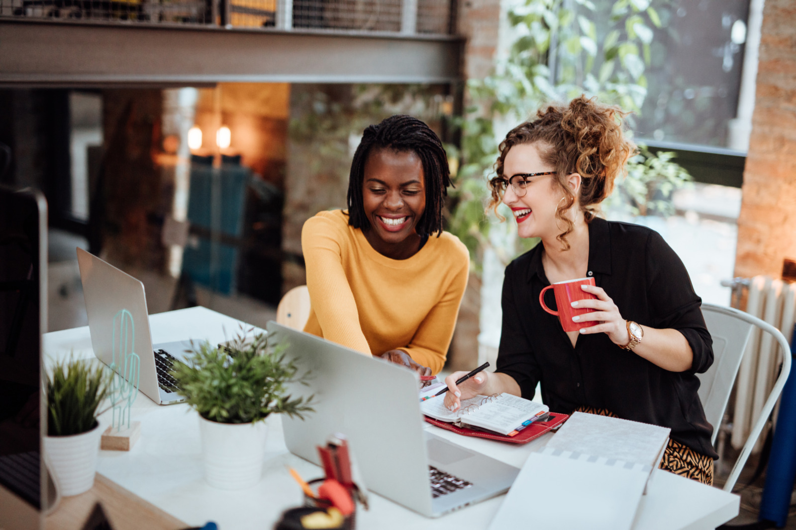 Two Businesswomen Working On Computer In Office